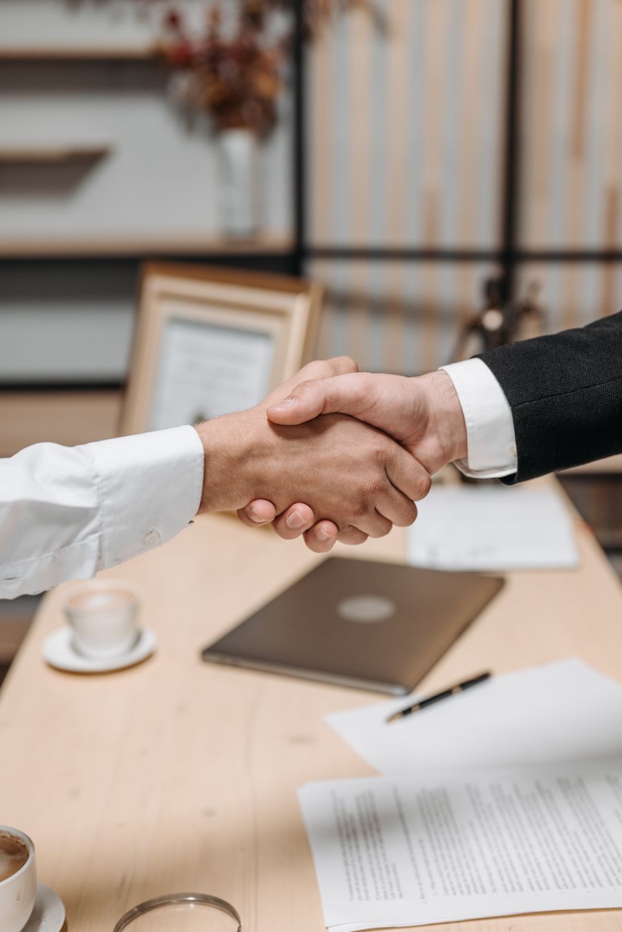 Two people shaking hands in an office, a verified partnership
